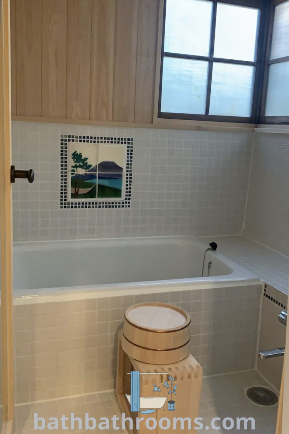 A cozy Japanese bathroom showcasing a toilet, tub, and a window by the bathtub, featuring traditional design elements. Experience the calming aesthetic of Japanese bathrooms while maximizing space and style. Explore more decor ideas at bathbathrooms.com.