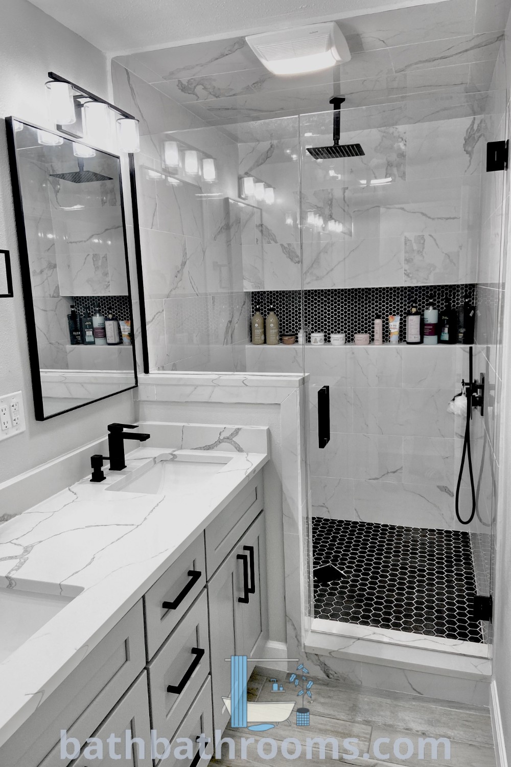 A stylish white bathroom with two sinks and a shower stall, beautifully decorated in black and white marble. This design offers unique ideas for restroom remodels and decor inspirations, perfect for enhancing any home. Discover more ideas for you at bathbathrooms.com.