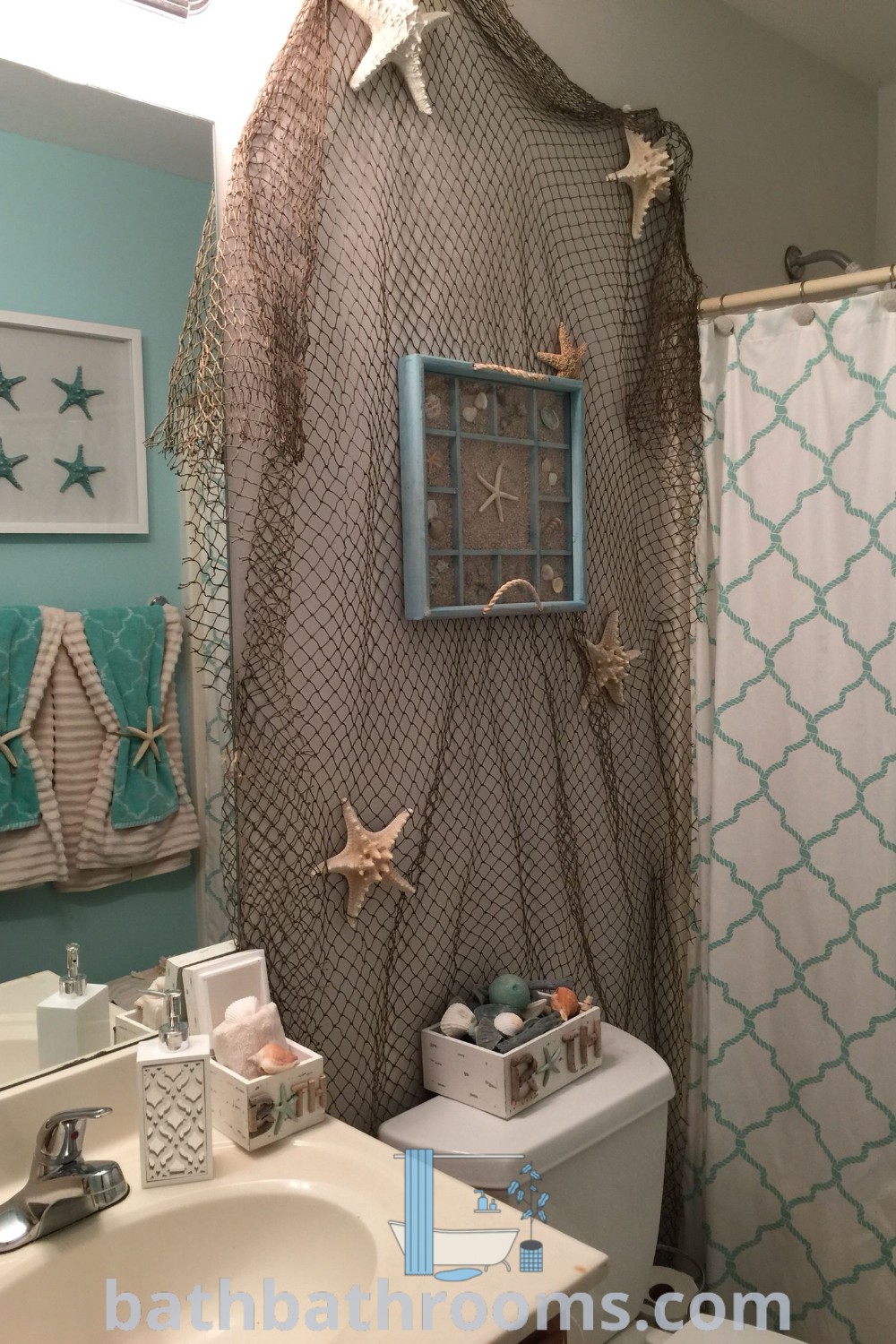 A small bathroom featuring a shower curtain and starfish decorations above the toilet, designed with beach-themed decor ideas for a cozy aesthetic. This ocean theme creates a tranquil atmosphere, perfect for budding design inspirations and ideas for your home at bathbathrooms.com.