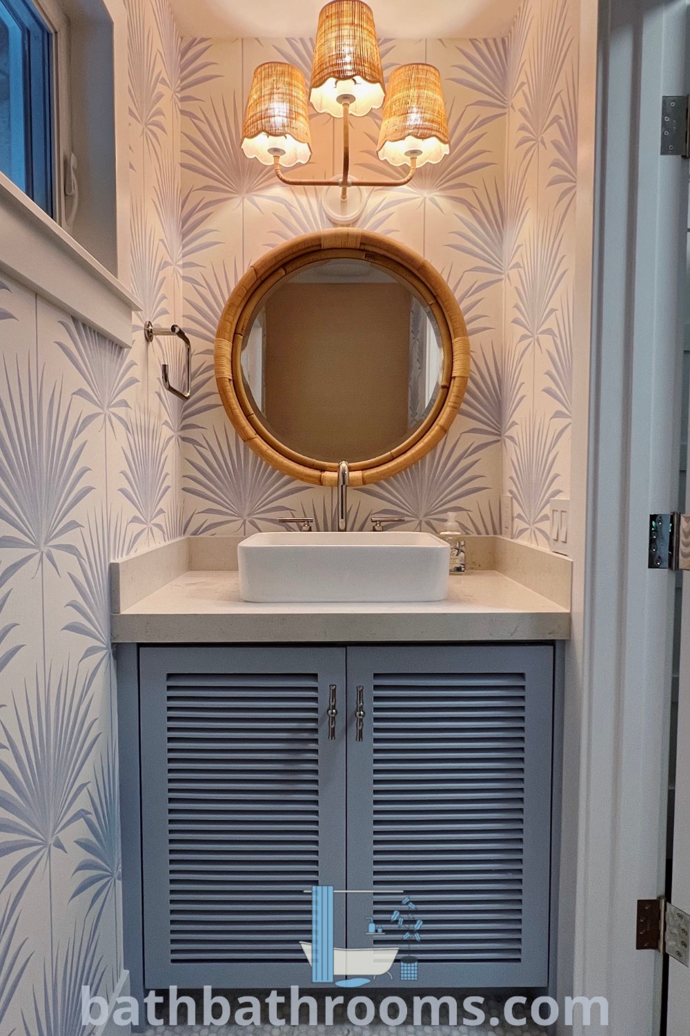 A small coastal half bath with a sink, mirror, and closet, featuring fun wallpaper and a beach house vanity, exemplifying beachy half bath decor ideas. Discover more coastal bathroom inspirations at bathbathrooms.com.