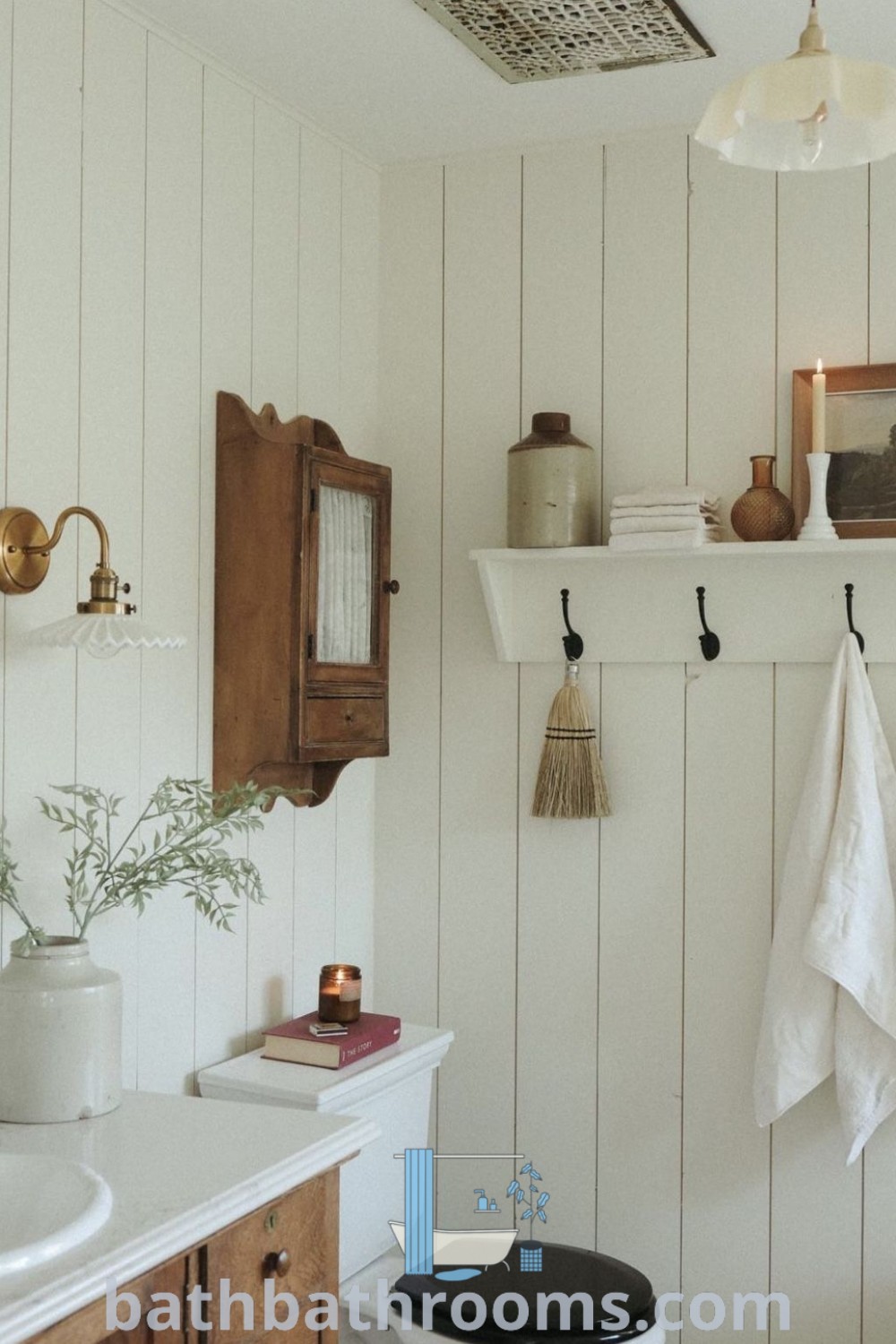 A cozy English cottage bathroom showcasing wood paneling, towels hanging above a clawfoot tub. It embodies cottage bathroom inspiration with features perfect for creating a warm and inviting atmosphere. Explore more decor ideas at bathbathrooms.com.