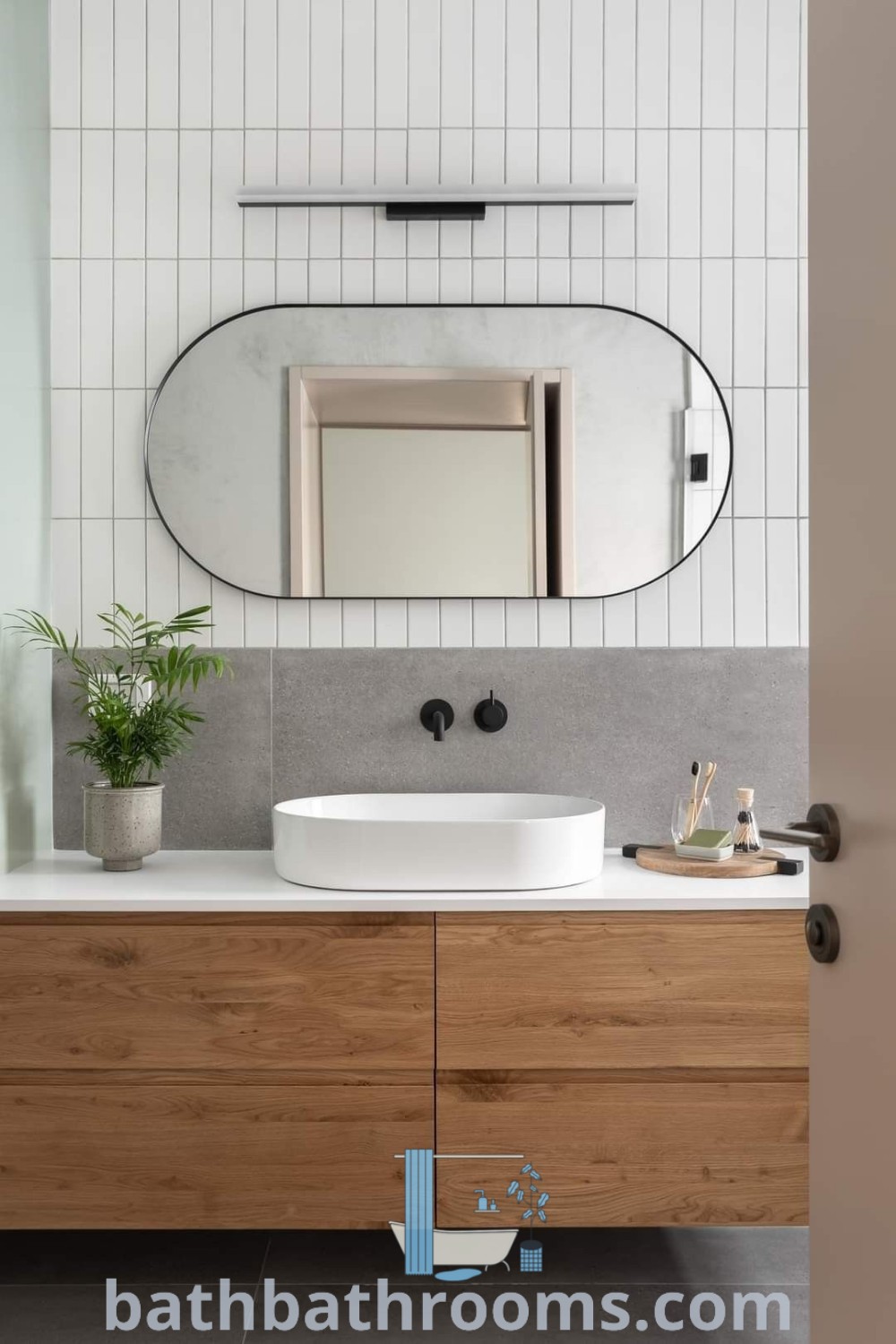 A cozy Japandi bathroom with a sink, mirror, and a plant on the counter, showcasing a stylish and functional design. This aesthetic incorporates elements ideal for small spaces while providing unique ideas for home transformations. Explore more decor inspirations for your bathroom at bathbathrooms.com.