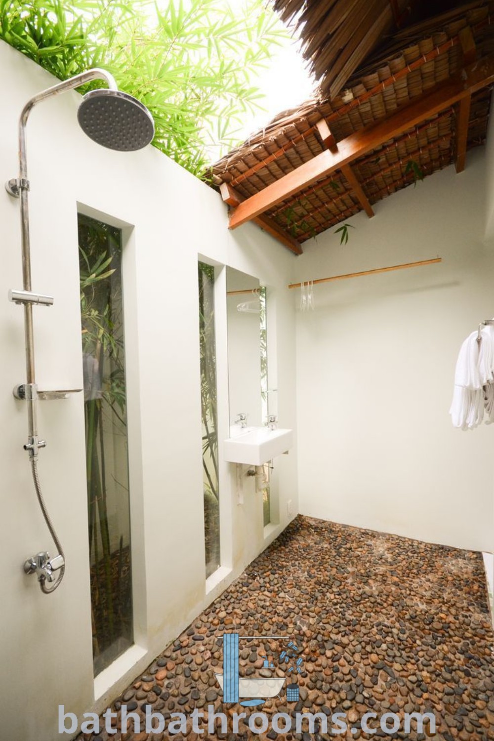 A clean and inviting bathroom featuring a shower head, sink, and mirror, designed for functionality and aesthetic appeal. This beautiful restroom embodies modern design ideas and decor inspirations, perfect for maximizing style and space. Discover more unique insights at bathbathrooms.com.