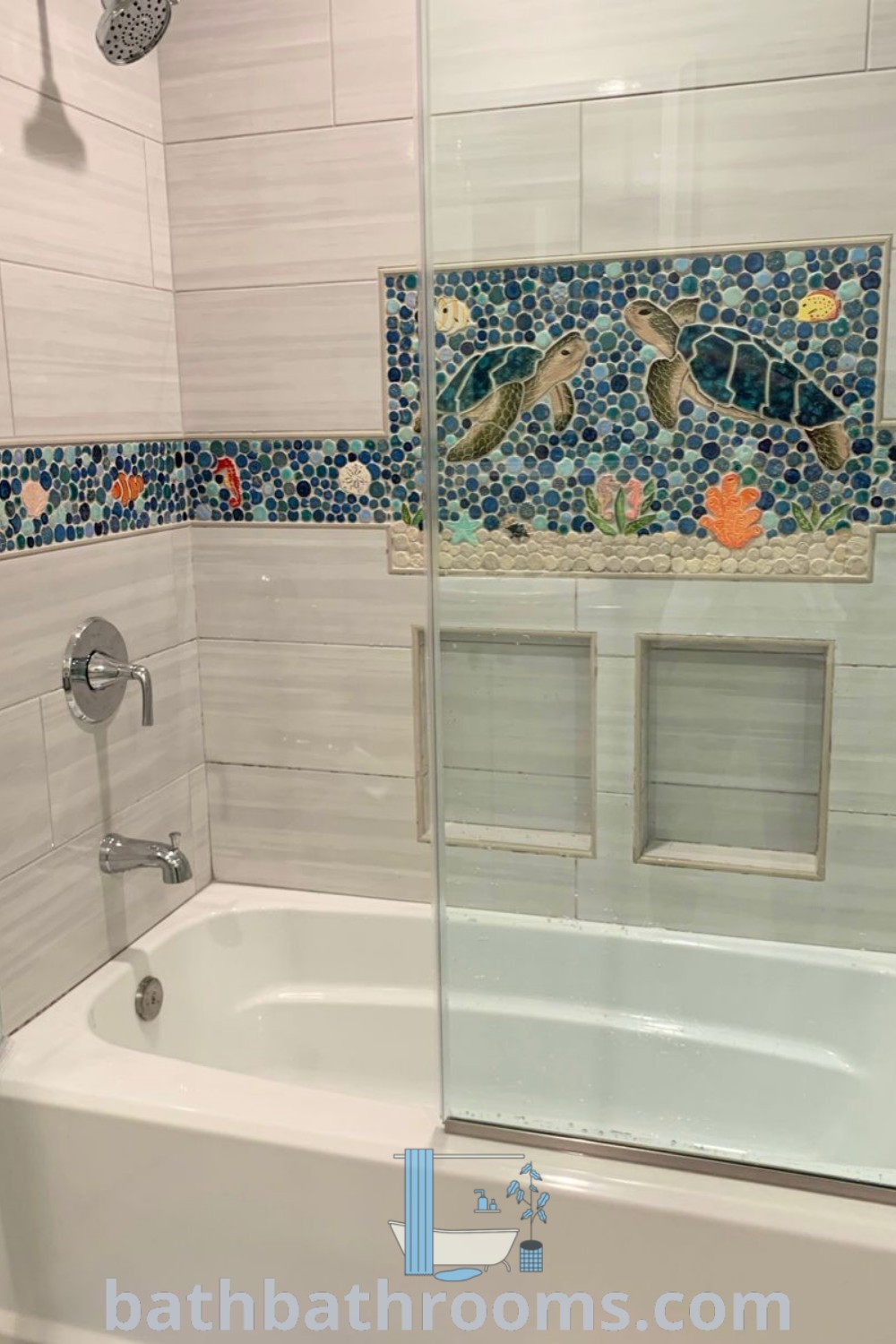 A cozy Turtle Tile Bathroom showcasing a bath tub next to a walk-in shower, adorned with sea turtle mosaics and beach-themed decor. This aquatic design exudes a tranquil atmosphere, perfect for relaxation. Explore more inspiring ideas at bathbathrooms.com.