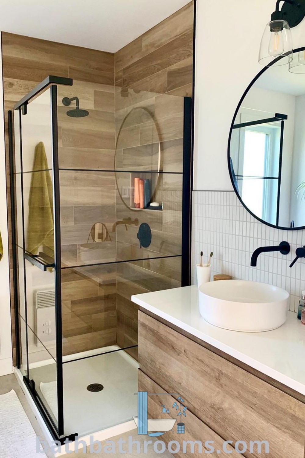 A Scandinavian bathroom with a shower, sink, and mirror, showcasing a cozy and functional design. This space features washroom tiles and decor ideas that inspire both style and practical use. Discover more design ideas at bathbathrooms.com.