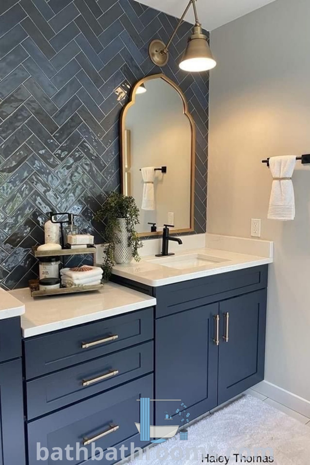 A modern bathroom with gray herringbone tile, two sinks, and a mirror, showcasing a stylish guest bathroom remodel. The design combines functionality and aesthetic appeal, offering inspiring ideas for your home at bathbathrooms.com.