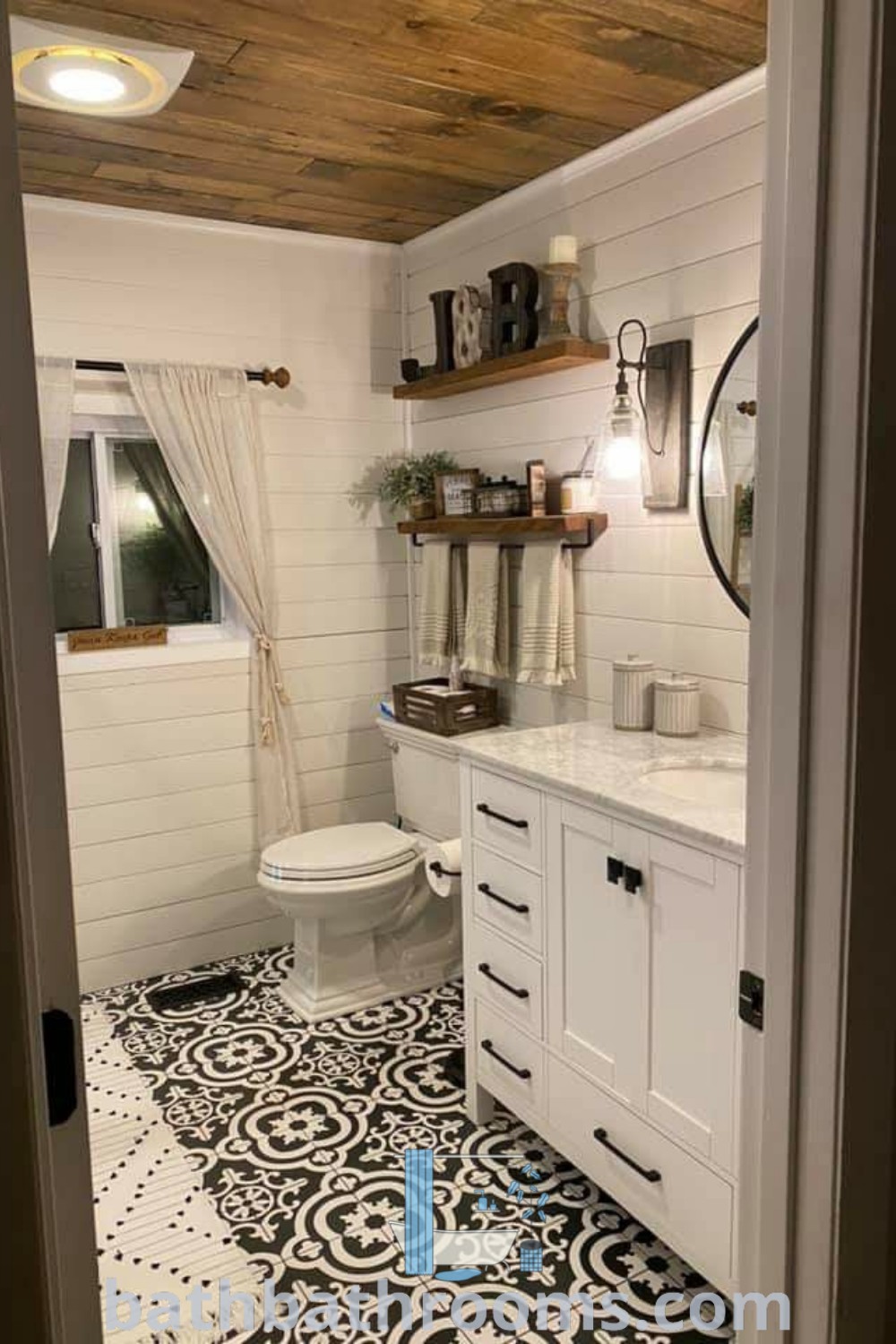 A white bathroom with black and white floor tiles, showcasing a Gaines farmhouse style. The design highlights inspiring bathroom decor ideas and themes, perfect for mobile home renovations. Explore more unique ideas at bathbathrooms.com.