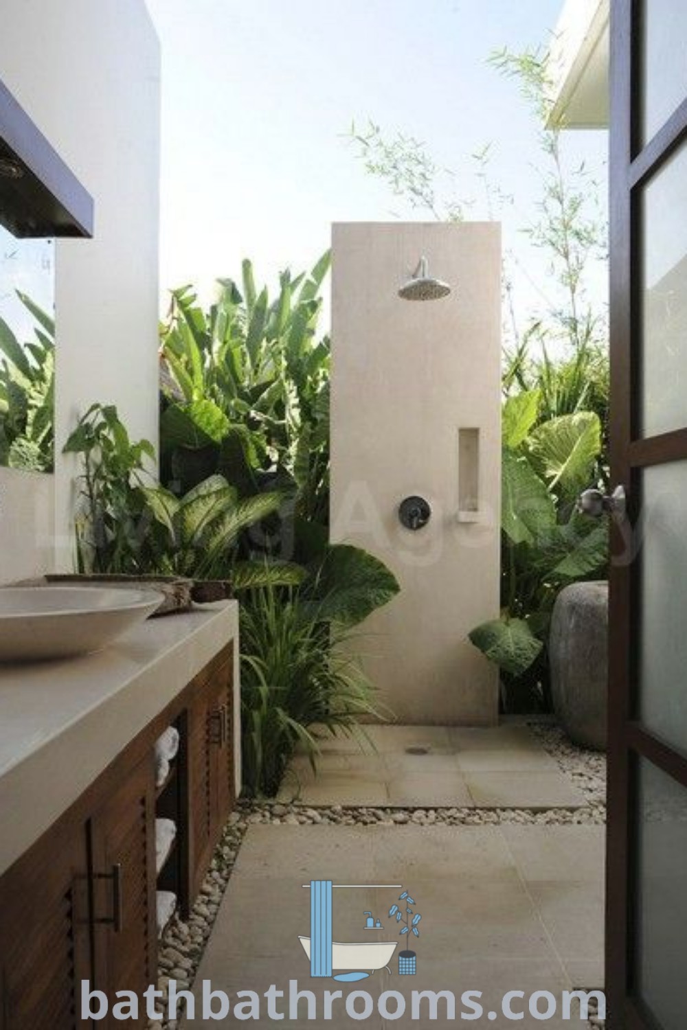 An inviting outdoor bathroom with a sink, mirror, and shower surrounded by greenery, showcasing nature living design ideas. This garden shower blends functionality with beauty, inspiring homeowners to create their own outdoor oasis. Discover more design tips at bathbathrooms.com.