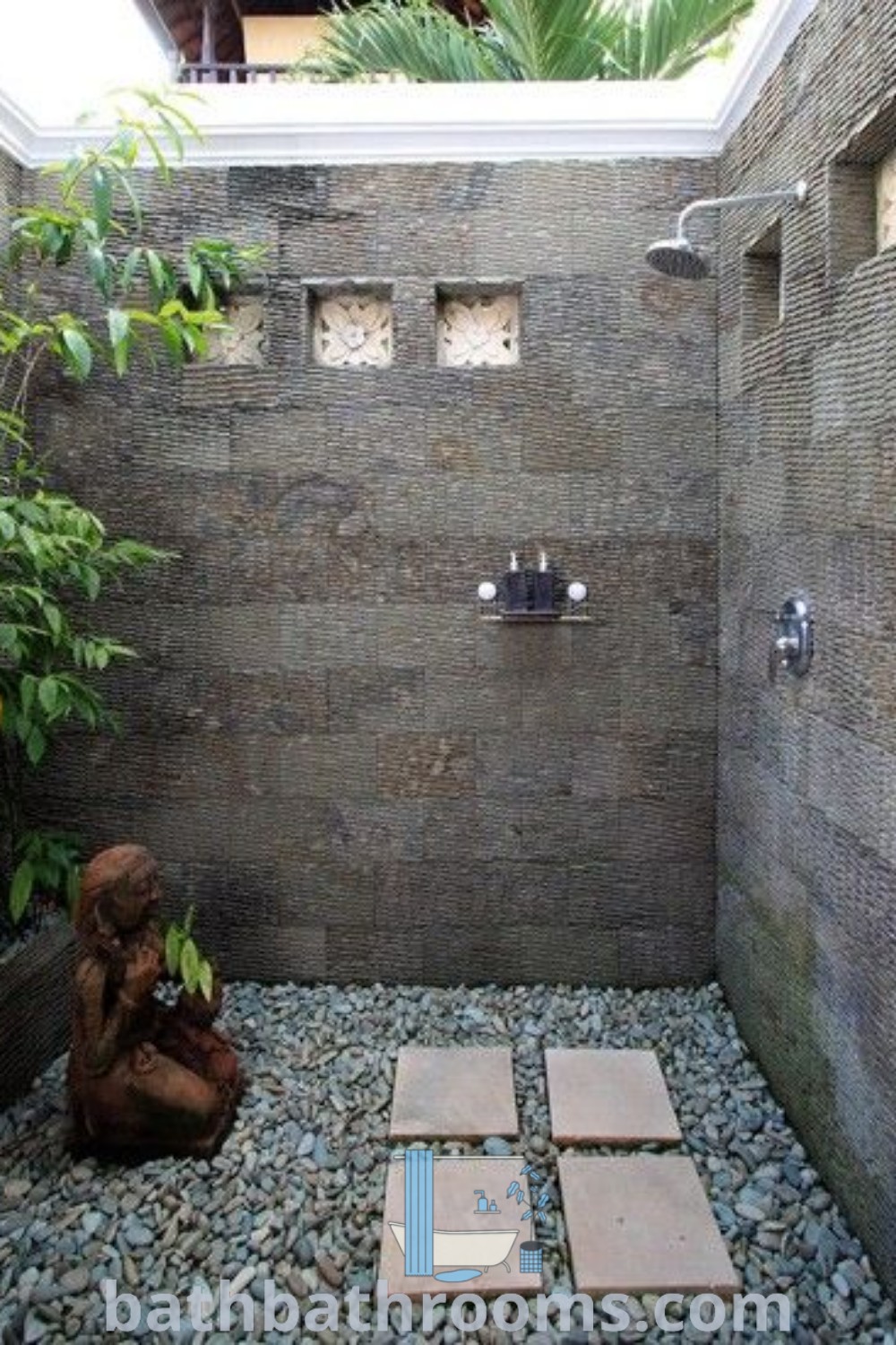 An outdoor shower with stone flooring and walls, showcasing an open-to-sky bathroom design that embodies African lodge decor and Bali outdoor styles. This setup serves as an inspiring example of unique ideas for transforming your home and enhancing your outdoor experience, as featured on bathbathrooms.com.