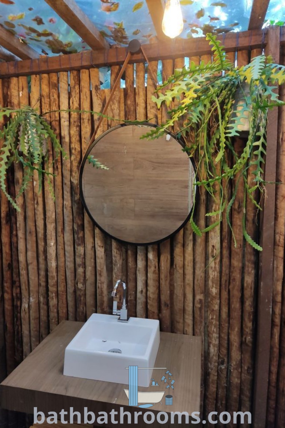 An elegant restroom with a sink and mirror surrounded by a bamboo fence and potted plants, showcasing cozy pool restroom ideas and unique cafe design inspirations. Discover more decor ideas for your home at bathbathrooms.com.