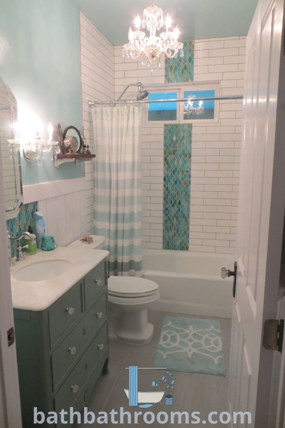 A beachy bathroom decorated in turquoise and white tiles, featuring a shower curtain, toilet, sink, and bathtub. This inviting design captures coastal charm with nautical colors and is perfect for small beach-themed spaces. Discover more ideas at bathbathrooms.com.