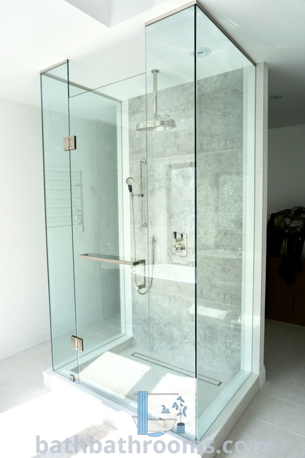 A glass shower enclosure featuring three sides, beautifully integrated into a bathroom. This design promotes a spacious feel and complements wet room ideas and bathroom feng shui principles. Discover more decor inspirations at bathbathrooms.com.