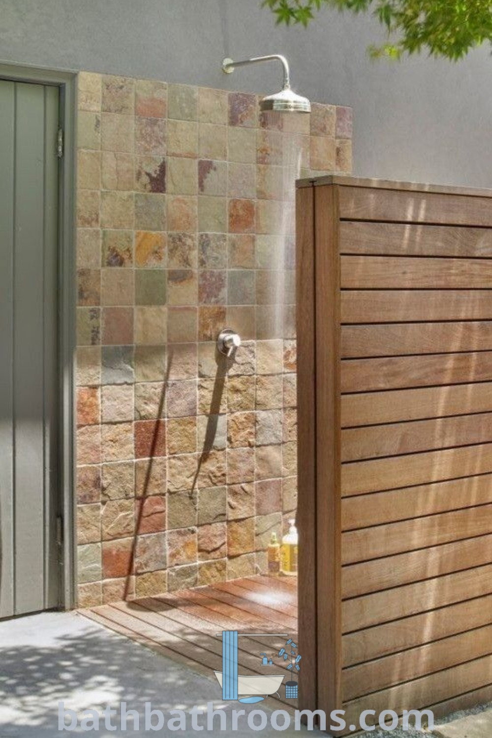 An outdoor shower with water flowing from the faucet, surrounded by wood slats, showcasing inviting outdoor shower designs. Ideal for garden showers and enhancing indoor outdoor bathrooms, this aesthetic adds functional beauty to your home. Explore more decor ideas at bathbathrooms.com.
