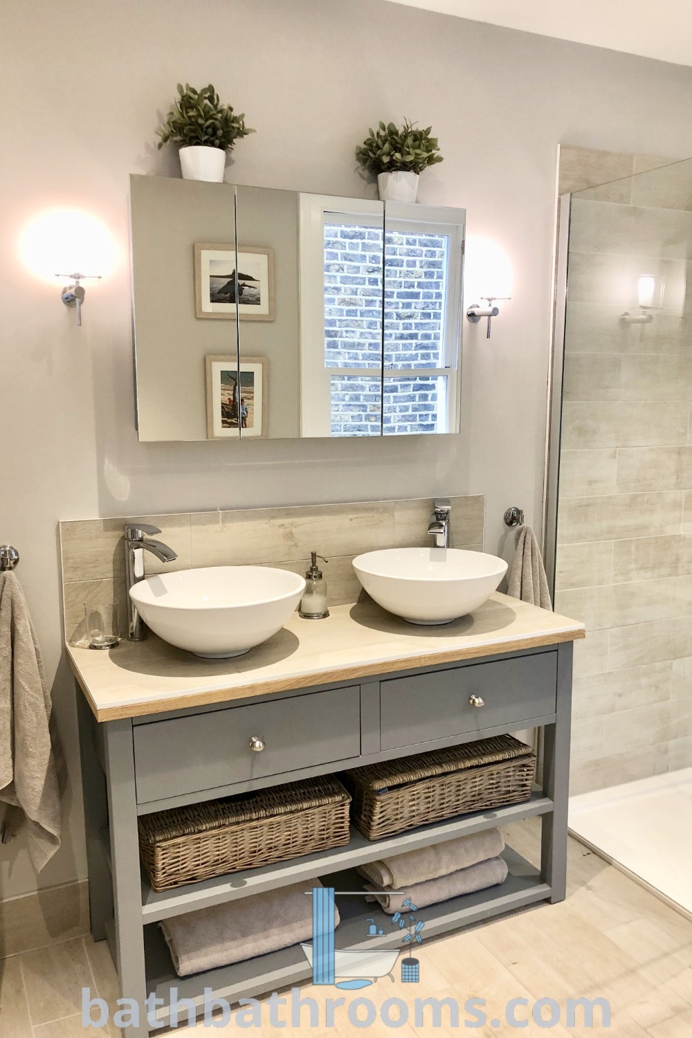 A stylish bathroom showcasing two sinks, a large mirror, and a walk-in shower, highlighting cozy design ideas. This setup offers functional inspirations for small double sink bathrooms, ensuring elegance and space maximization. Discover more tips at bathbathrooms.com.