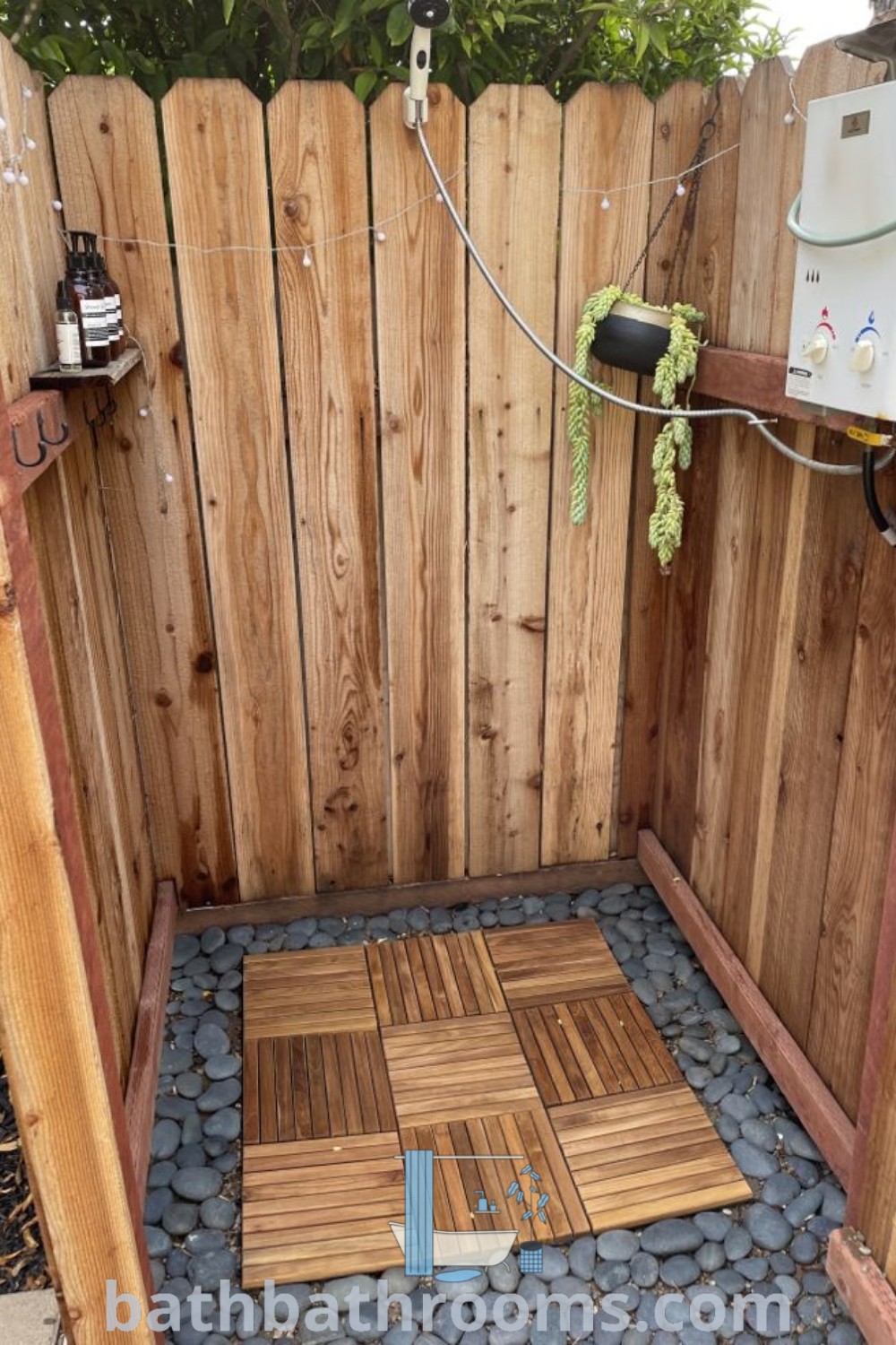 A beautiful outdoor shower with a wooden fence and rocks, showcasing a mounted showerhead. This inspiring design offers cozy ideas for outdoor bathroom setups and unique outdoor shower enclosures, enhancing your backyard