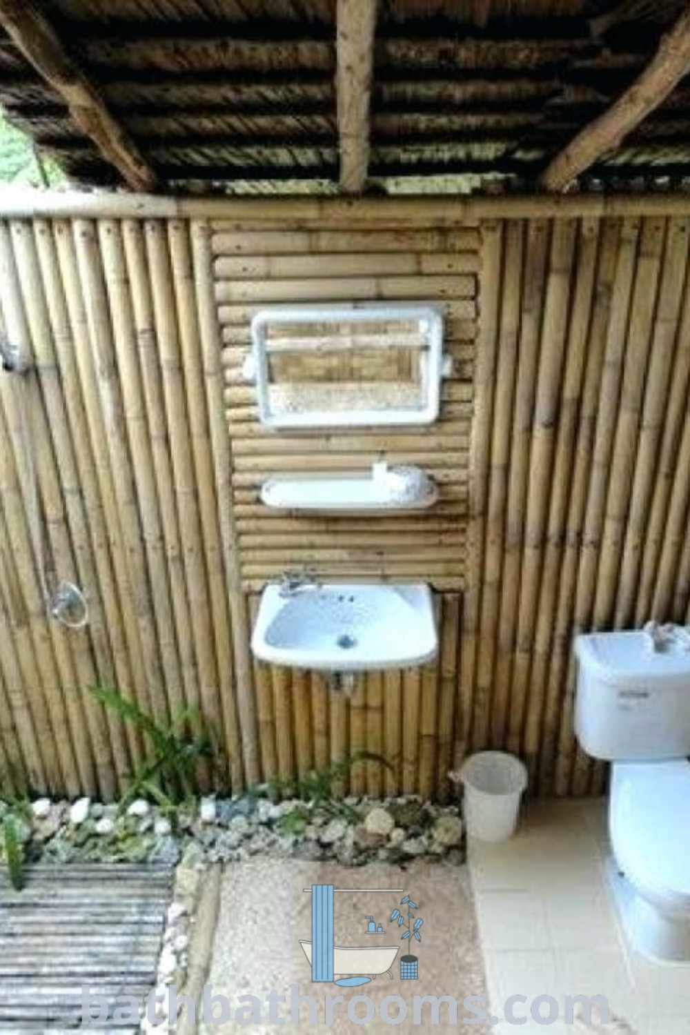 A bamboo outdoor bathroom with two toilets and a sink, surrounded by lush greenery, showcasing unique ideas for outdoor patio design and shower DIY. Discover inspiring decor ideas at bathbathrooms.com.