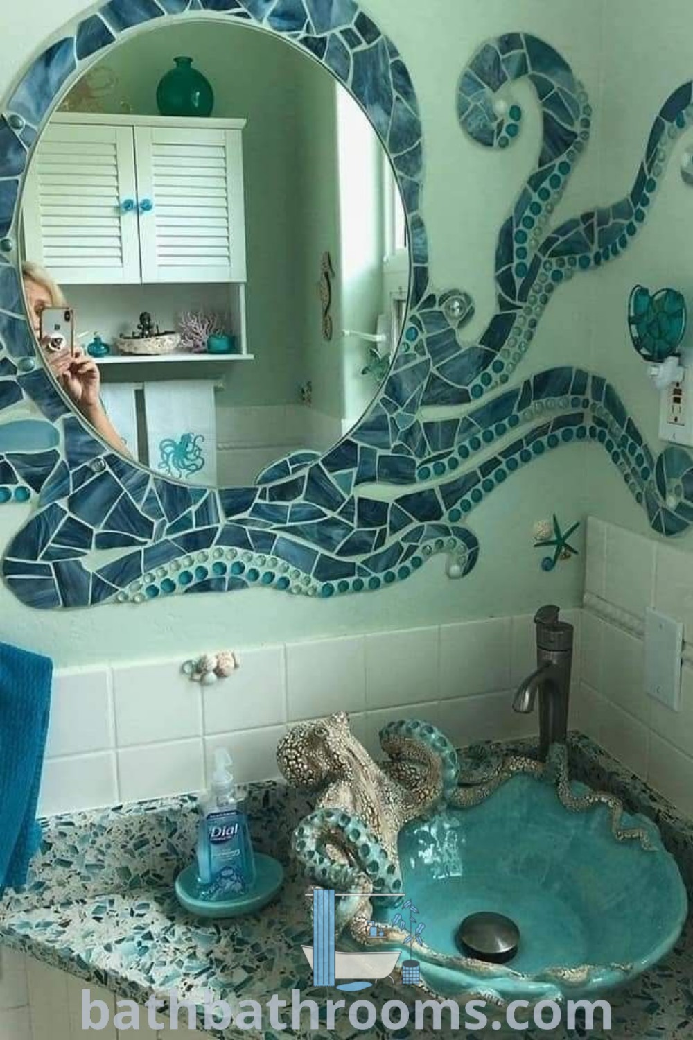 An octopus mirror above a bathroom sink enhances the decor with a whimsical touch, reflecting ocean-themed aesthetics ideal for a beach house bathroom. This unique bathroom design brings cozy ideas and vibrant colors to life. Explore more decor inspirations at bathbathrooms.com.