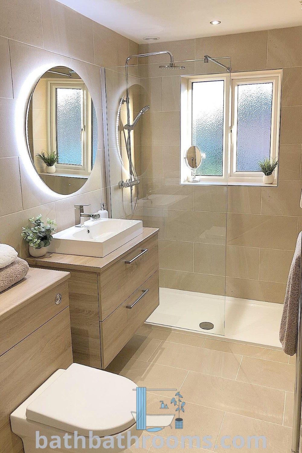 A cozy small bathroom featuring a sink, toilet, and shower stall in beige and white decor, showcasing minimalist style. Discover inspiring design tips and decor ideas for small spaces at bathbathrooms.com.