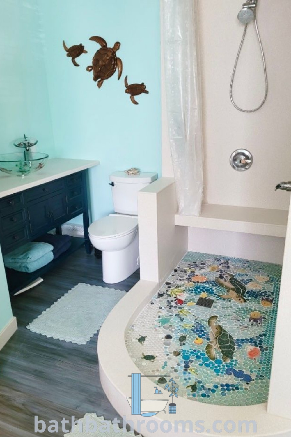 An ocean-inspired bathroom with blue walls and white fixtures, showcasing decor ideas like mosaic elements and coastal style. This design creates a cozy and refreshing atmosphere, perfect for house or apartment transformations. Explore more inspirations at bathbathrooms.com.