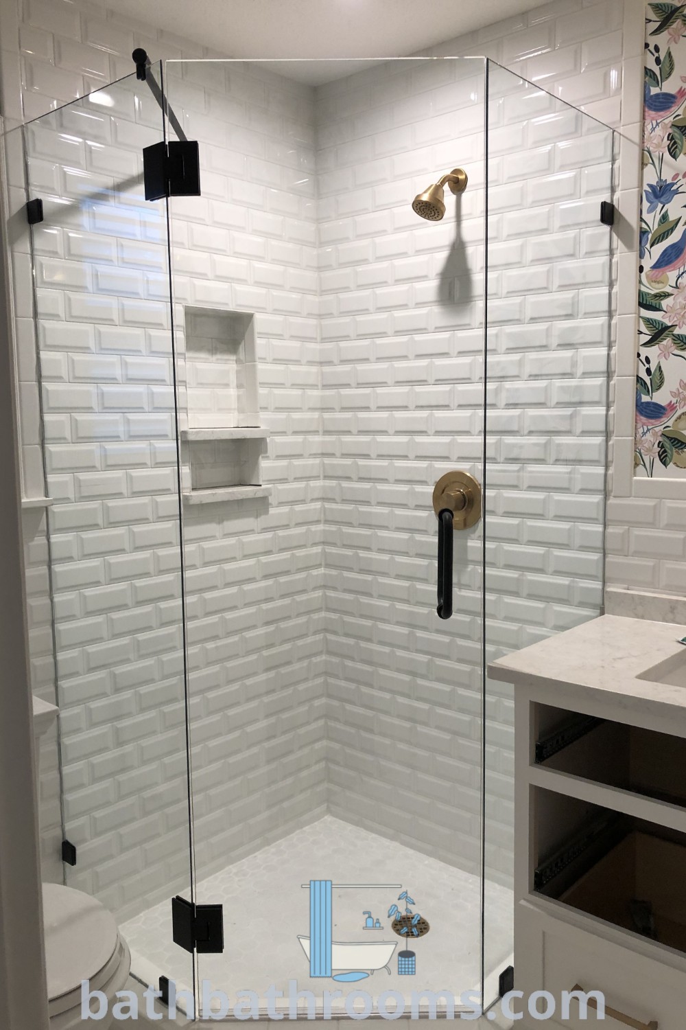 A stylish small bathroom featuring a neo angle walk-in shower adjacent to a white toilet, with all-tiled walls and cozy design elements. The corner shower maximizes space while providing a modern touch. Get inspired by unique decor ideas at bathbathrooms.com.
