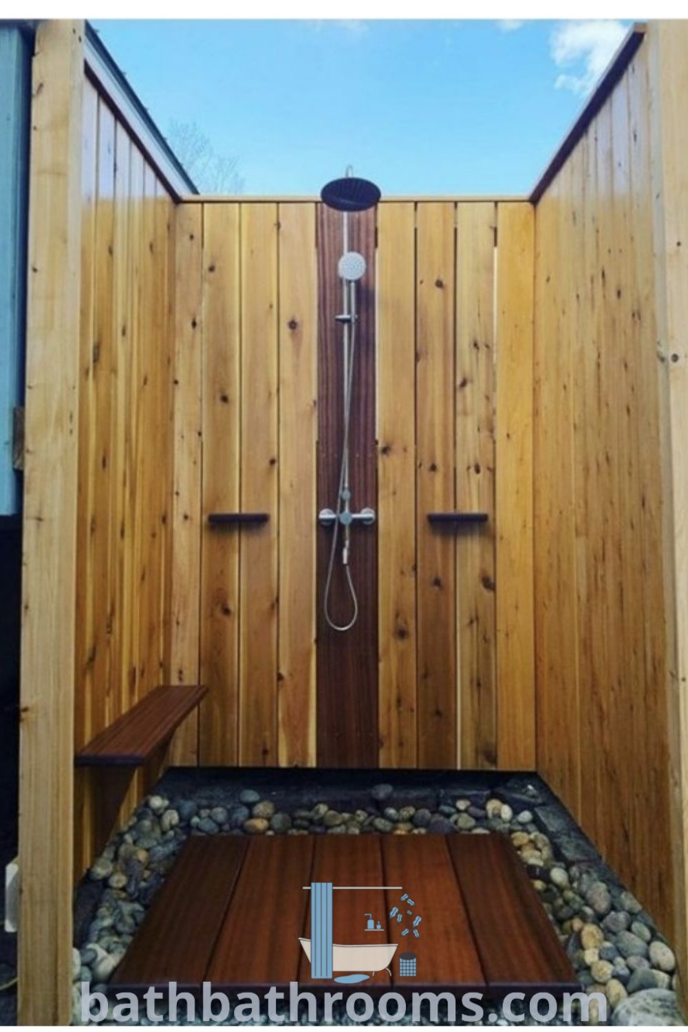 A wooden shower stall with a bench, framed by a blue sky, exemplifies cozy bathroom design ideas for outdoor showers and unique backyard retreats. Experience inspiring decor ideas for your home at bathbathrooms.com.