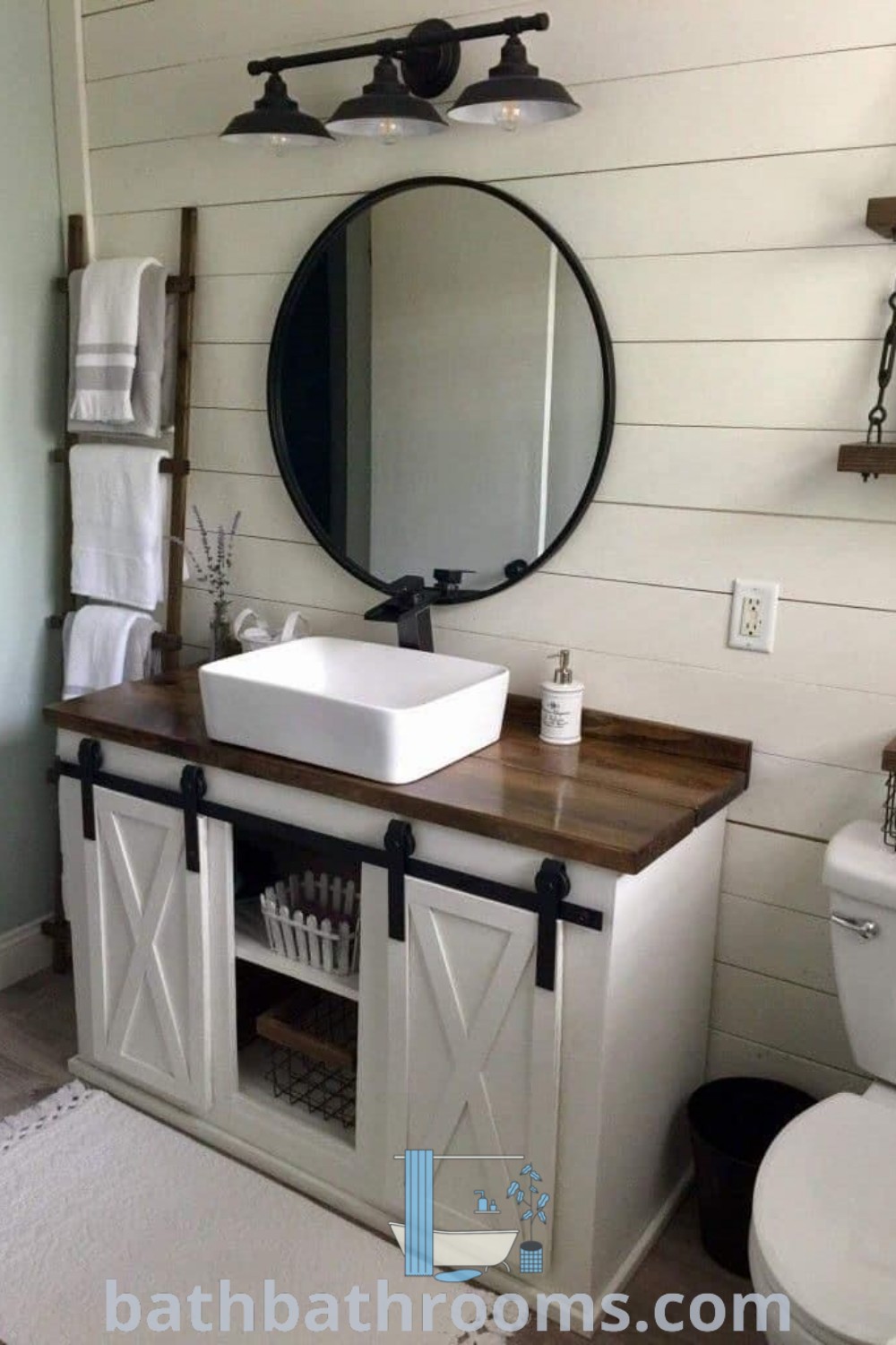 A modern bathroom featuring a sink, mirror, and toilet with stylish tiles and clear storage bins. Embracing farmhouse style, this cozy design offers ideas for bathroom remodels. Explore bathbathrooms.com for more design inspirations and tips.