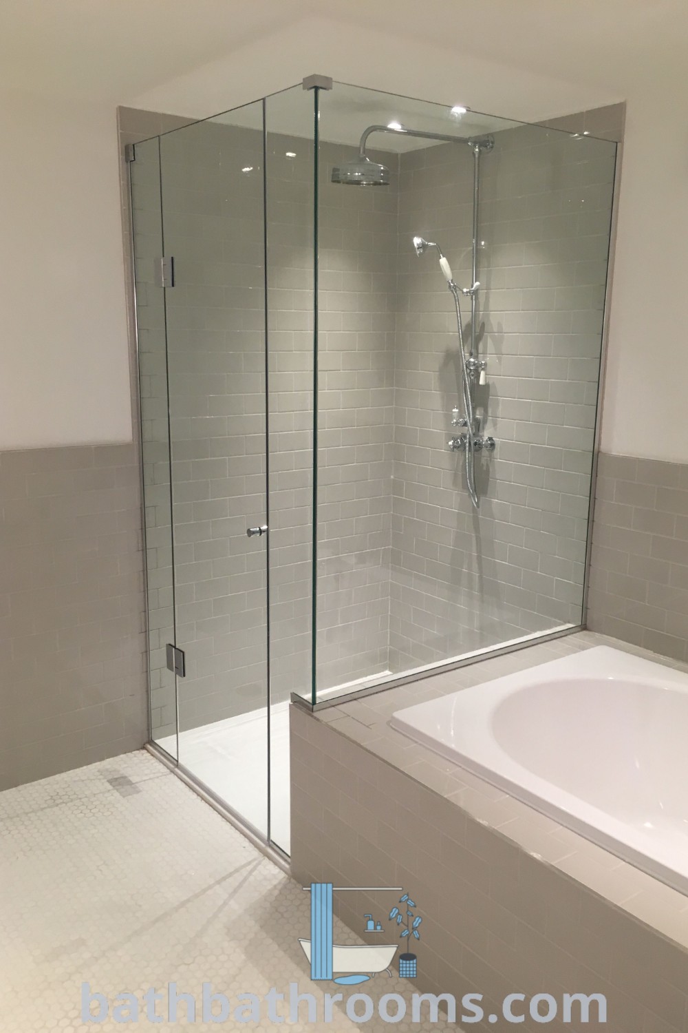 An elegant white bath tub sitting next to a walk-in shower, showcasing a cozy design idea for a bathroom. This bath and shower combo highlights functional beauty and maximizes space, offering stylish inspirations for a perfect style fusion. Explore more unique ideas at bathbathrooms.com.