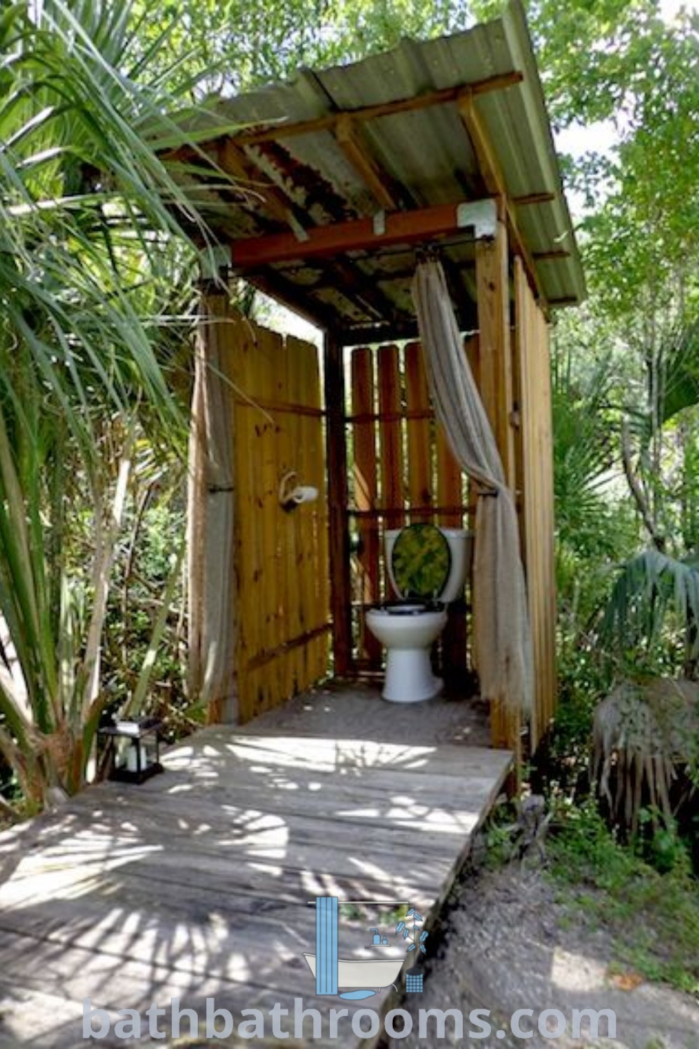 An outdoor restroom in a wooden structure, surrounded by trees and plants, showcasing an inspiring outdoor bathroom design. The setting combines rustic charm with functionality, ideal for unique ideas and cozy aesthetics. Discover more outdoor bathroom inspirations at bathbathrooms.com.