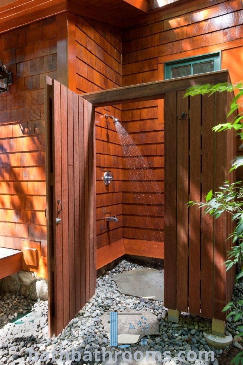 An outdoor shower in the corner of a wooden building with water flowing from it, showcasing inspiring outdoor shower ideas and a perfect lake house aesthetic. Explore cozy bathroom designs and decor inspirations at bathbathrooms.com.